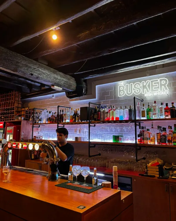 Camarero tirando una cerveza en la barra de De Locos